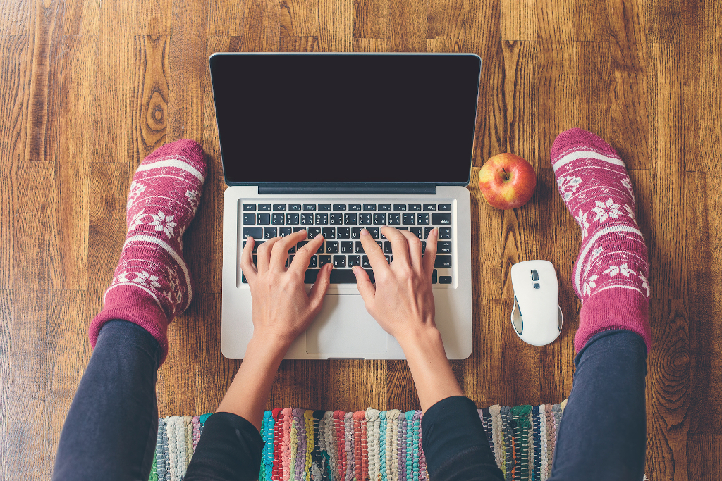Homeoffice: Frau sitzt auf dem Fußboden und tippt auf einem Laptop; Date mit dem Blog, produktiv bloggen, regelmäßig bloggen