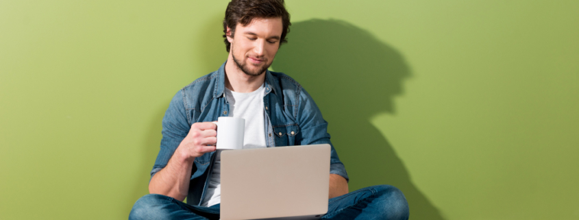Regelmäßig Content veröffentlichen, entspannt bloggen Symbolbild, Mann sitz entspannt mit Laptop und Kaffeetasse auf dem Boden und arbeitet