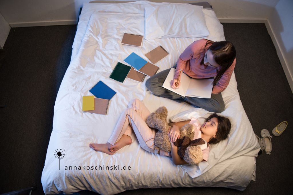 Frau sitzt nachts auf dem Bett und arbeitet, während ihre Tochter neben ihr schläft, Blognacht, produktiv bloggen, Networking